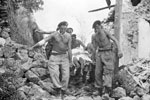 Royal Marines stretcher out an injured victim of the earthquake, August 1953. Image from Imperial War Museums, A32662